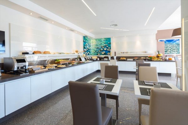 Nowoczesna restauracja z bufetem i artystycznym wystrojem na ścianie.