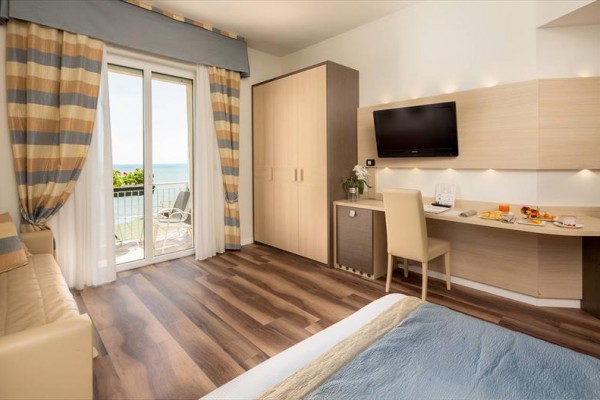 Nowoczesny pokój hotelowy z balkonem i widokiem na morze.