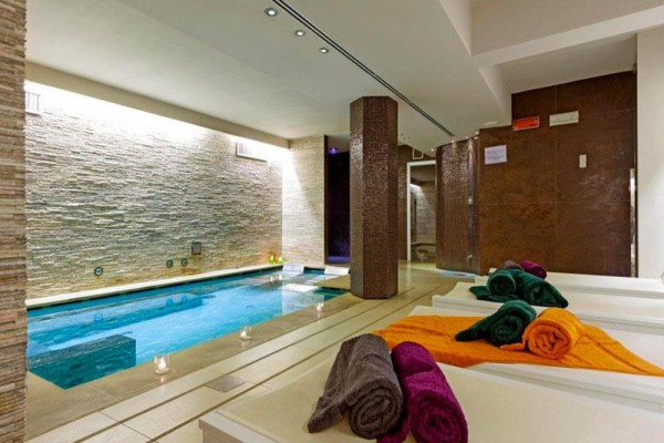 Wnętrze centrum wellness z basenem, leżakami i złożonymi ręcznikami.