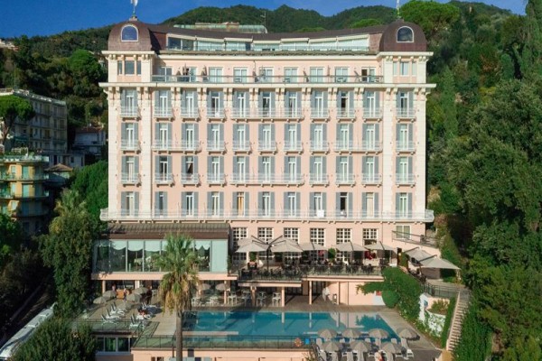 Duży hotel położony jest w górzystej okolicy, z basenem na pierwszym planie.