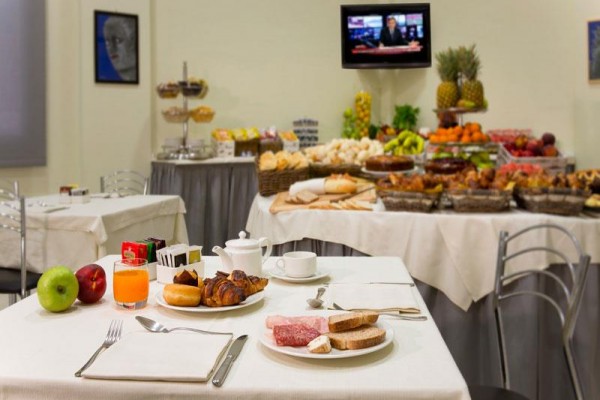 Nakryty stół z pieczywem, owocami i napojami w restauracji z bufetem.
