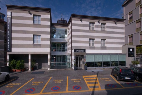 Wejście do hotelu z parkingiem oznaczonym żółtymi liniami.