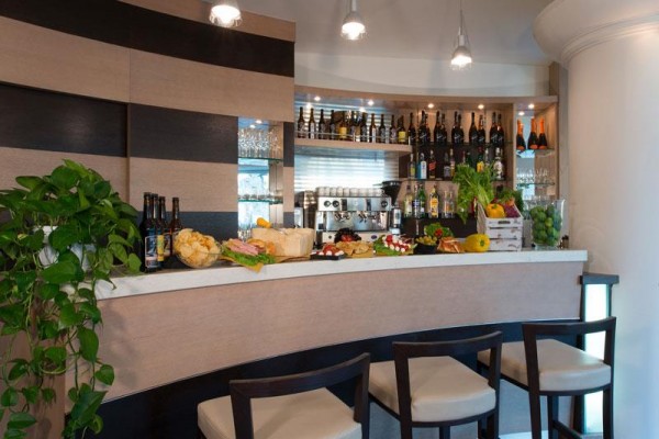 Elegancki bar z przekąskami i butelkami alkoholu na półkach.