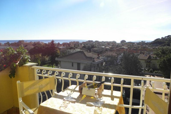 Balkon z widokiem na miasto i morze w oddali.