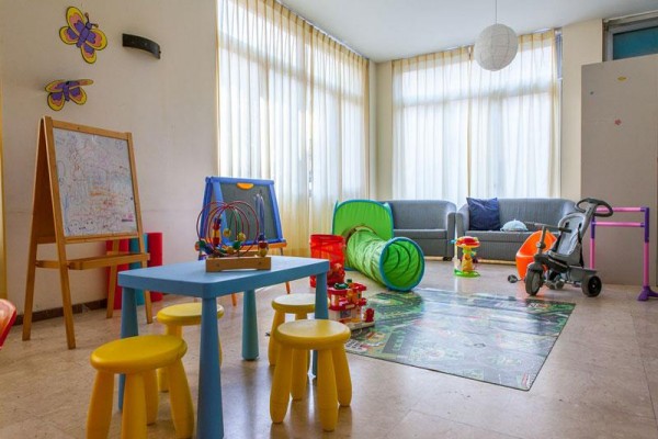 Pokój zabaw dla dzieci z kolorowymi meblami i zabawkami.