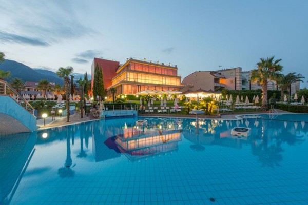 Nowoczesny hotel z oświetleniem odbijającym się na powierzchni basenu o zmierzchu.