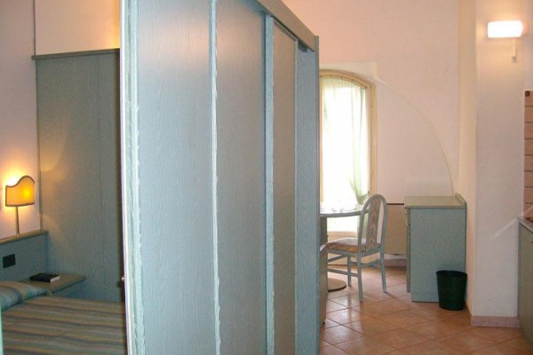 Nowoczesny pokój z drewnianymi panelami i meblami, oświetlony lampą.