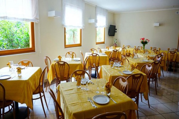 Restauracja z przygotowanymi stolikami i żółtymi obrusami.