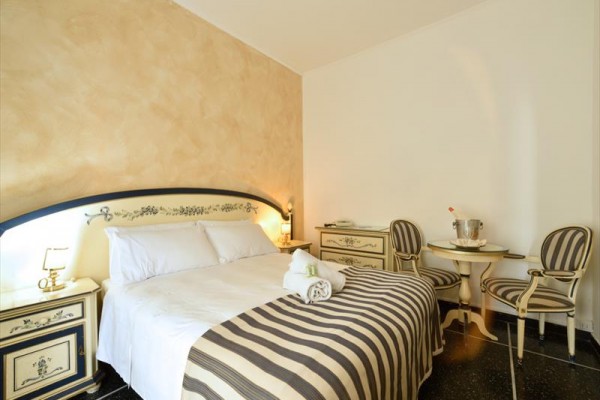 Elegancki pokój hotelowy z podwójnym łóżkiem i stylowymi meblami.