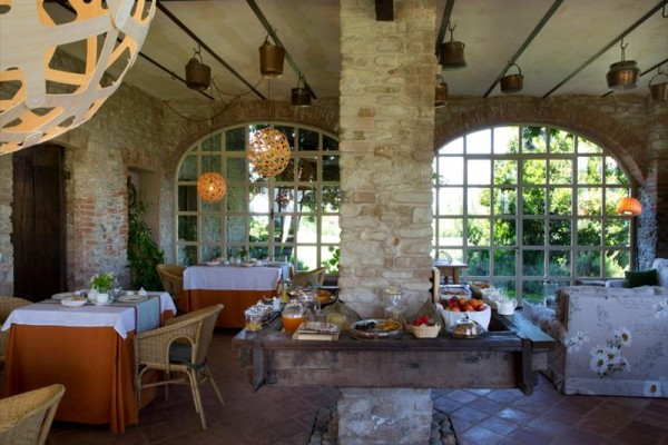 Wnętrze rustykalnej restauracji z dużymi oknami i stołami przygotowanymi na bufet.
