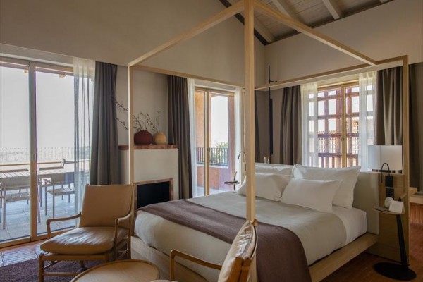 Luksusowy pokój hotelowy z łóżkiem z baldachimem i balkonem.