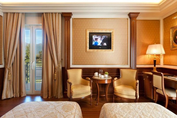 Luksusowy pokój hotelowy z eleganckimi meblami i balkonem.