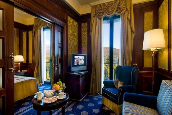 Luksusowy pokój hotelowy z widokiem na krajobraz, wygodnym fotelem i telewizorem.