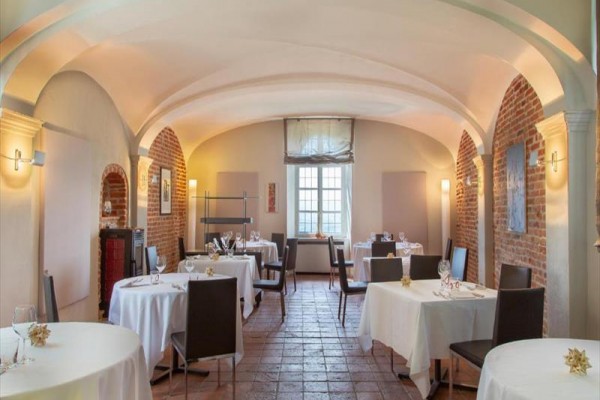 Elegancka restauracja z sklepionym sufitem i ceglanymi ścianami.