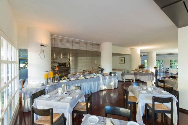 Restauracja z nakrytymi stołami i stołem bufetowym z jedzeniem i napojami.