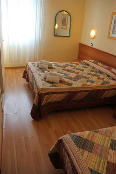Mały pokój hotelowy z dwoma łóżkami i złożonymi ręcznikami.