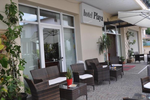 Zewnętrzne miejsca do siedzenia hotelu z meblami rattanowymi pod markizą.