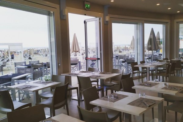 Restauracja z widokiem na plażę i miejscami do siedzenia na zewnątrz.