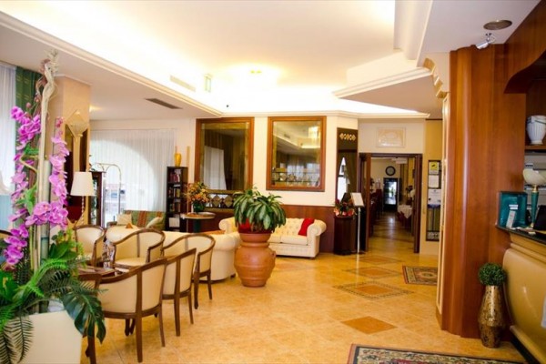 Eleganckie lobby hotelowe z wygodnymi miejscami do siedzenia i kwiatową dekoracją.