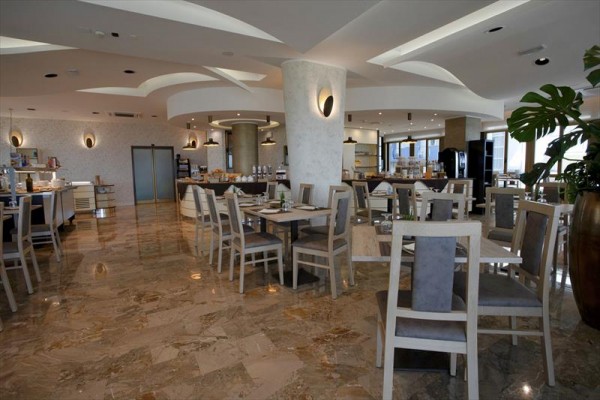 Nowoczesna restauracja z marmurową podłogą i stylowymi meblami.