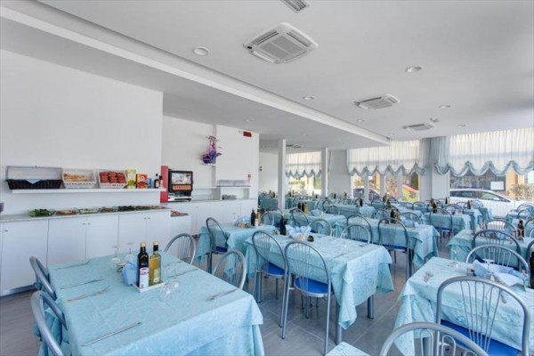 Restauracja z niebieskimi obrusami i metalowymi krzesłami przy stolikach przygotowanych dla gości.