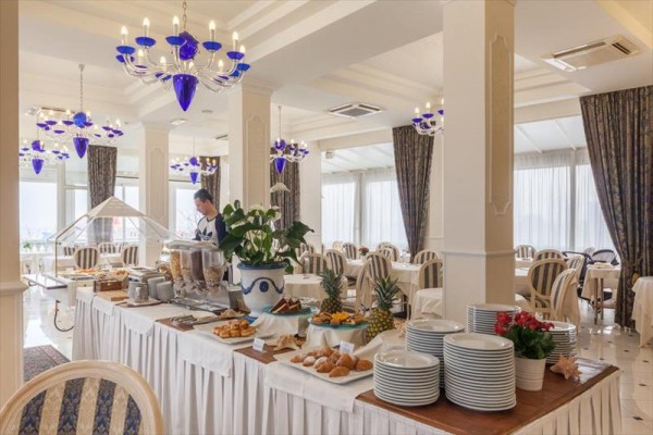 Elegancka restauracja z bufetowym stołem, na którym są owoce i pieczywo.