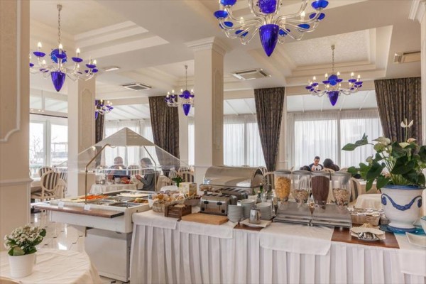 Restauracja z obfitym bufetem śniadaniowym i niebieskimi żyrandolami.