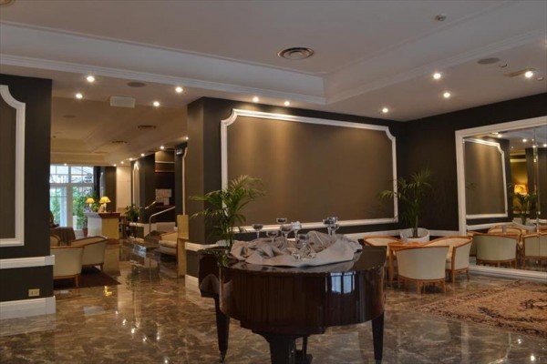 Elegancki salon hotelowy z fortepianem i wygodnymi fotelami.
