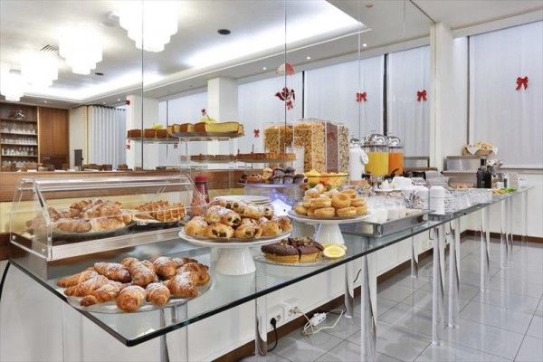 Bufetowy stół z różnymi słodkimi wypiekami i napojami w hotelu.