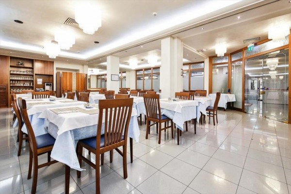 Nowoczesna restauracja z drewnianymi meblami i białymi obrusami.