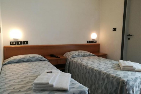 Dwa pojedyncze łóżka w pokoju hotelowym z ręcznikami na każdym łóżku.