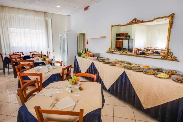Restauracja z nakrytymi stołami i bufetowym stołem pełnym różnych potraw.