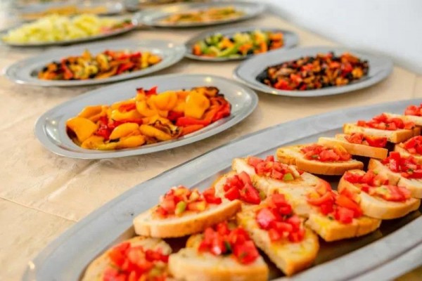 Talerze z różnymi przystawkami, na pierwszym planie bruschetta z pomidorami.