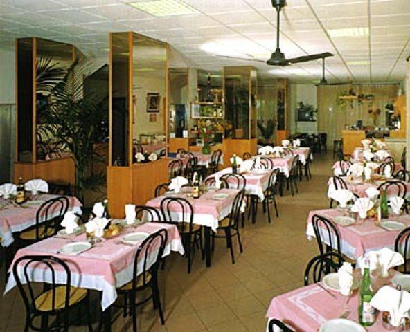 Elegancko nakryta restauracja z różowymi obrusami i drewnianymi krzesłami.