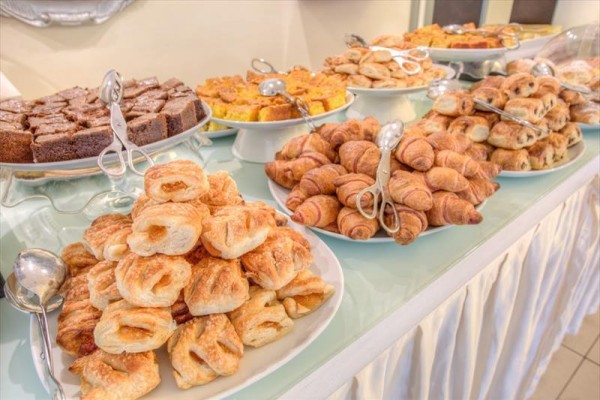 Wybór różnych rodzajów pieczywa i ciast na stole bufetowym.