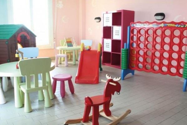 Sala zabaw z kolorowymi meblami i zabawkami dla dzieci.