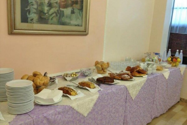 Bufetowy stół z pieczywem, owocami i napojami.