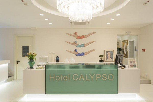 Recepcja hotelu Calypso z nowoczesnym oświetleniem i dekoracją pływaków na ścianie.