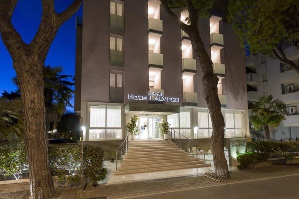 Wejście do hotelu Calypso wieczorem z oświetlonymi schodami i drzewami po bokach.