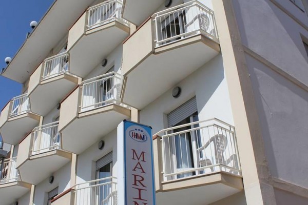 Budynek hotelu z kilkoma balkonami i napis 