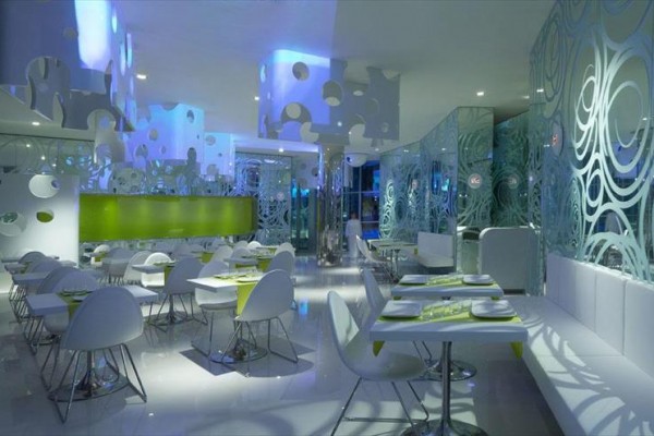 Nowoczesna restauracja z futurystycznym designem i niebieskim oświetleniem.