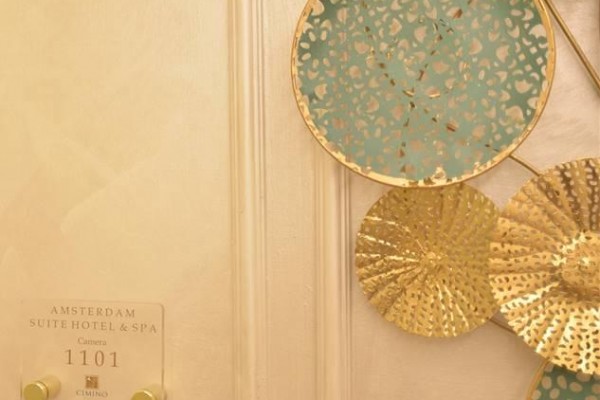 Złote i niebieskie dekoracje na ścianie obok drzwi pokoju 1101 w hotelu Amsterdam Suite Hotel & Spa.