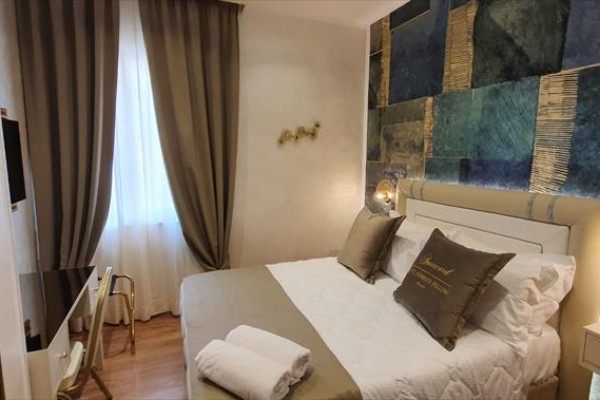 Nowoczesny pokój hotelowy z podwójnym łóżkiem, dekoracyjną ścianą i zasłonami w oknie.