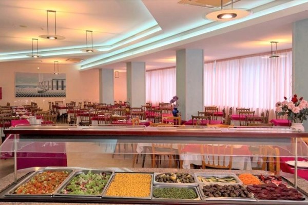 Restauracja z bufetem pełnym jedzenia i drewnianymi krzesłami.
