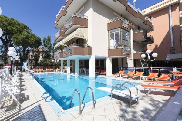Hotel posiada odkryty basen otoczony leżakami i parasolami.