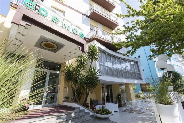 Wejście do hotelu otoczone palmami i zielenią.