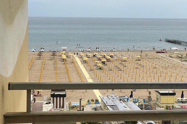 Widok na plażę z pustymi parasolami i otwartym morzem.