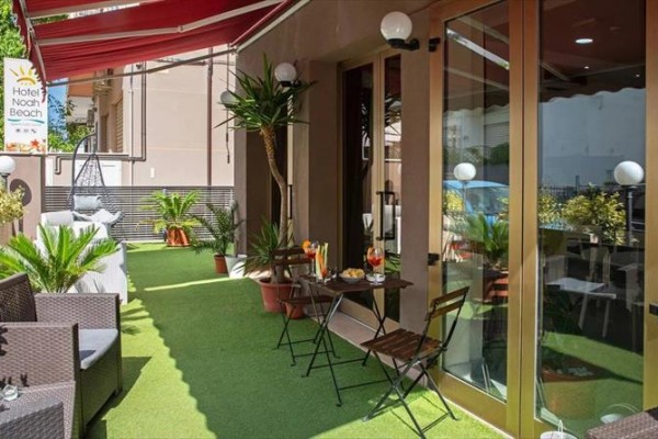 Taras hotelowy z miejscami do siedzenia na zewnątrz i roślinami.