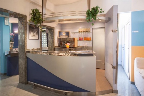 Nowoczesny hotelowy bar z ekspresem do kawy i dekoracjami z roślin i napojów.