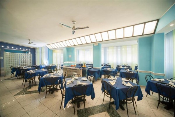 Restauracja z niebieskimi obrusami i okrągłymi stołami.